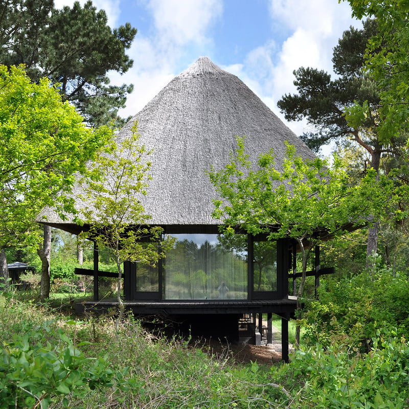 The exterior of a contemporary summer house with a thatched roof
