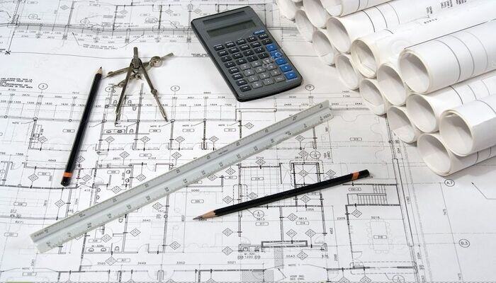 A calculator, ruler, and pencils on a blueprint for Technical Architecture-1