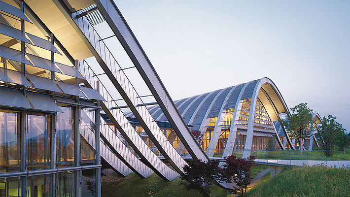 A modern building with a curved roof and large glass windows