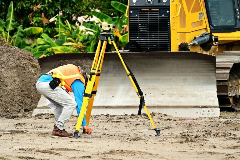 An image showing a man surveying land as part of site analysis in architecture