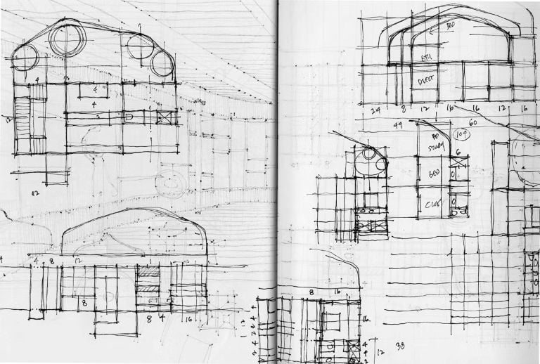 An image showing an architect sketching building concepts by hand on paper