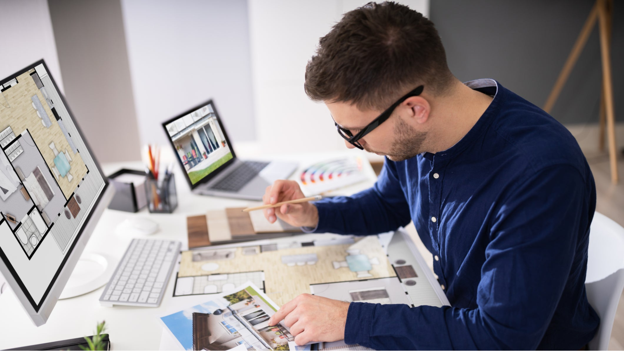 An interior designer on their work desk observing a rendered image