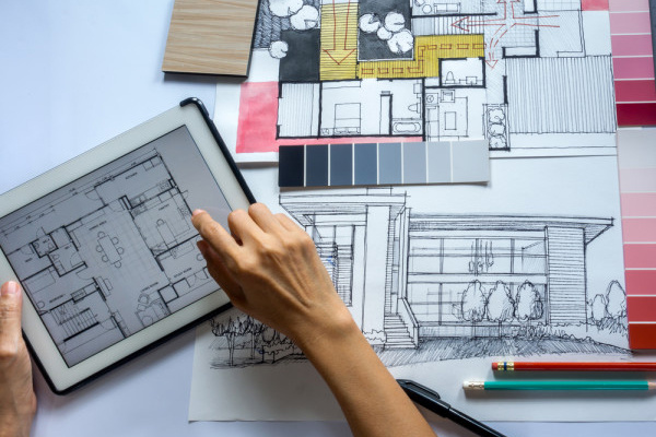 An interior designer translating their sketch from paper to a 2D drawing