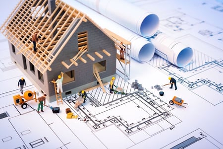 An image of a man holding a 3D model surrounded by its 2D elevation and sectional drawings