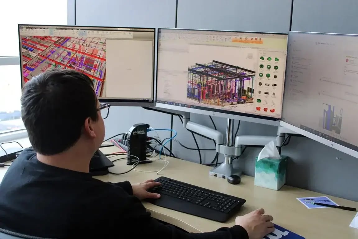 BIM Professional reviewing BIM model on multiple screens.