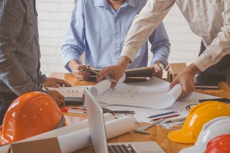 Civil engineers reviewing construction plans and drawings.