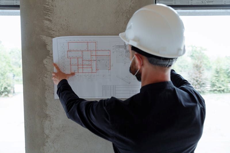 Construction Project Engineer reviewing construction blueprint