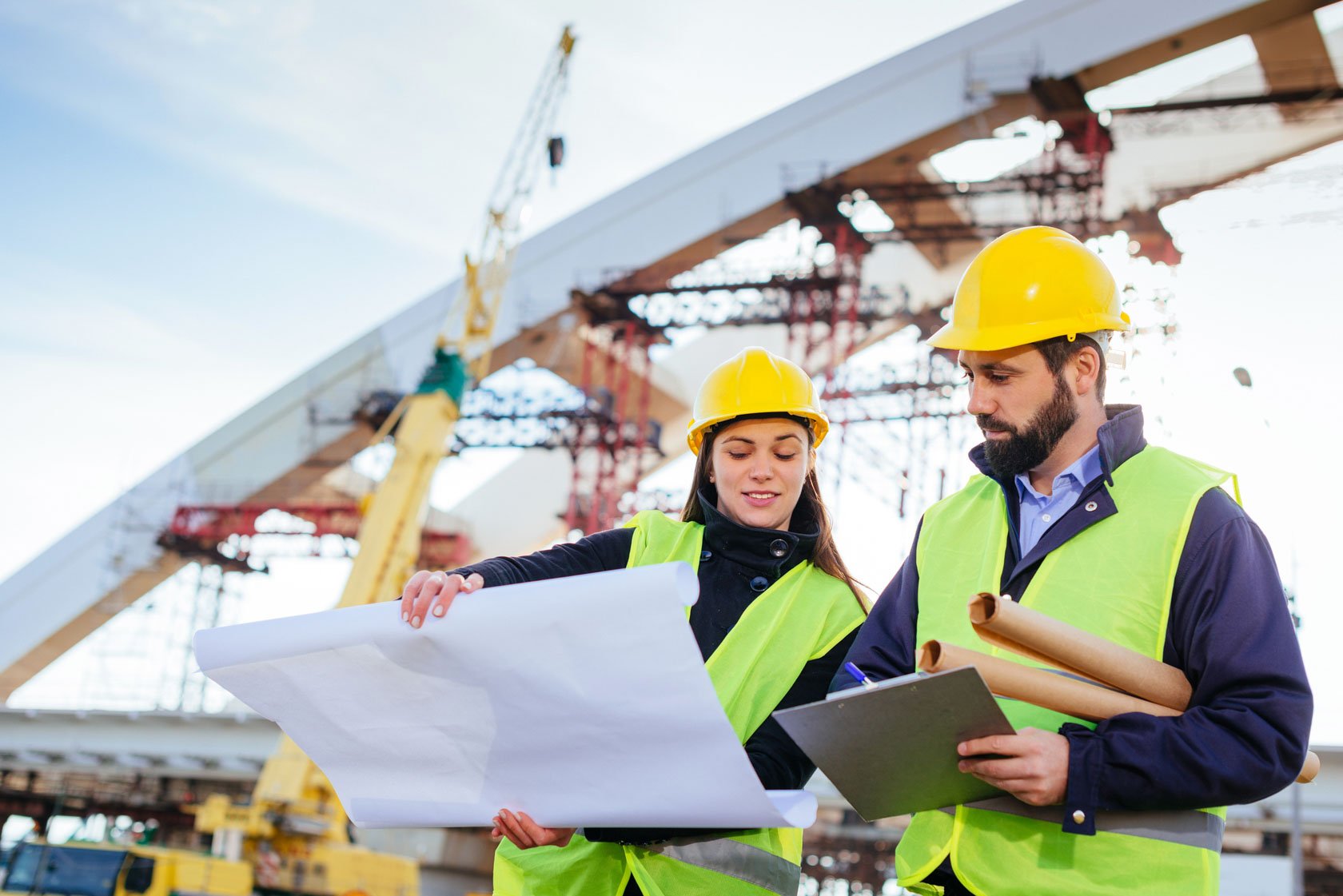 Construction engineers reviewing drawings on site