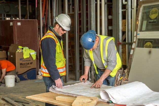 Construction inspectors looking at building design sheets for inspection