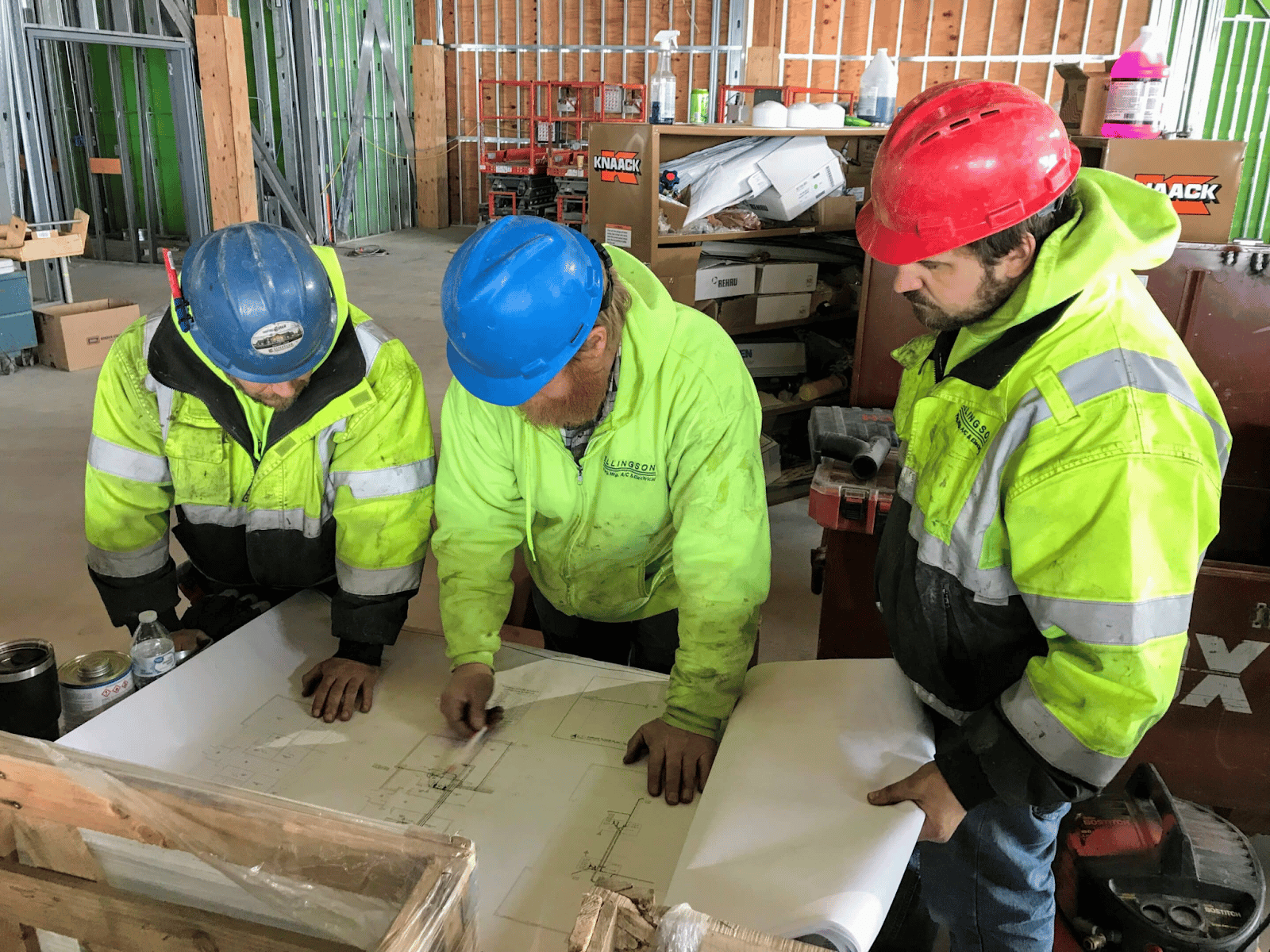 Construction team reviewing MEP drawings on site.