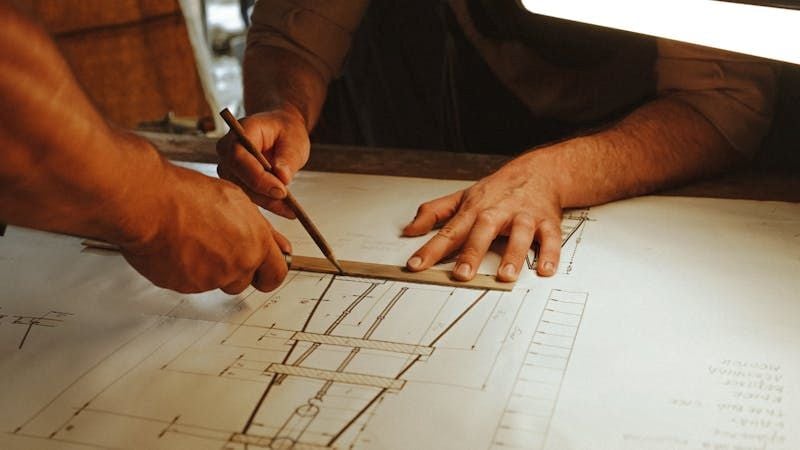 Hands drafting construction blueprint