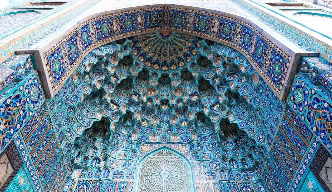 a photograph of the grand arch adorned with Islamic art at the Blue Mosque of Tabriz in Iran