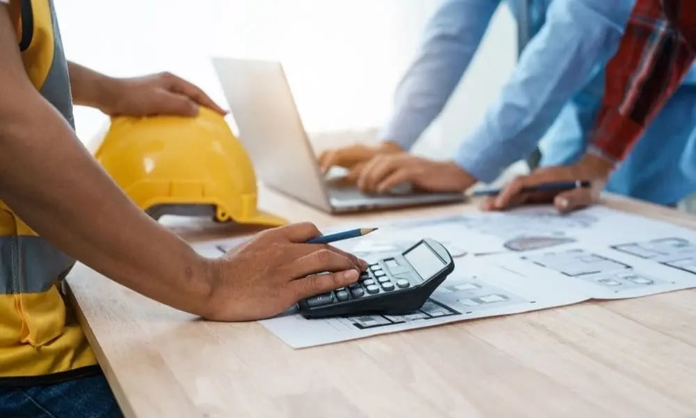Quantity surveyor calculating construction costs from project plans
