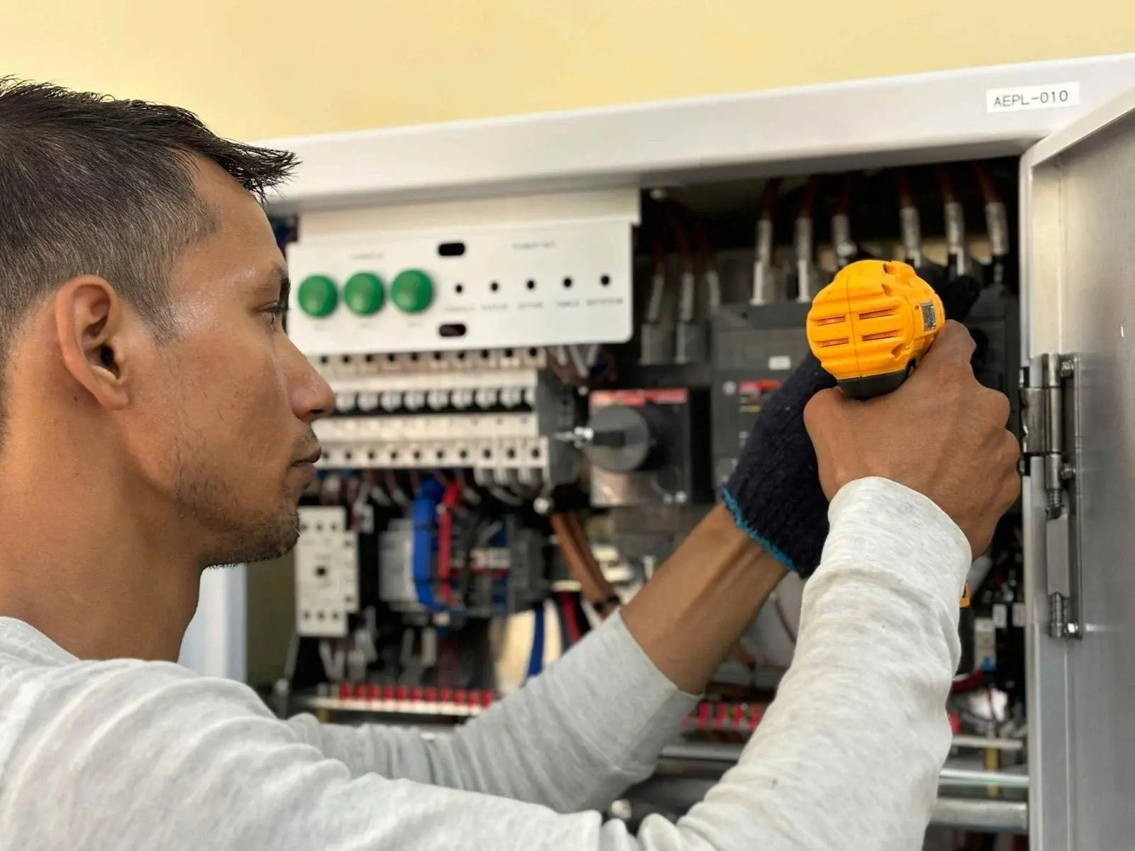 Technician inspecting electrical panel for load analysis.
