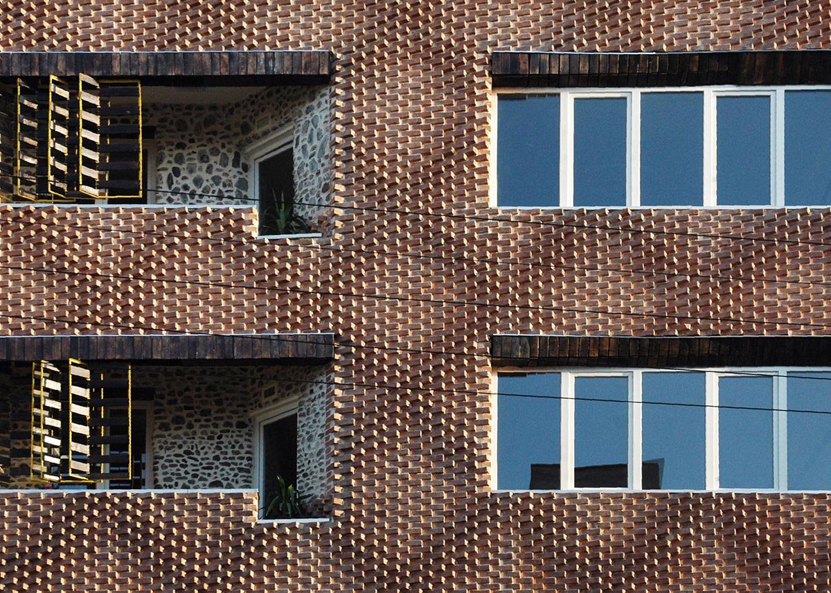 The front of a building showing brick facade with multiple windows