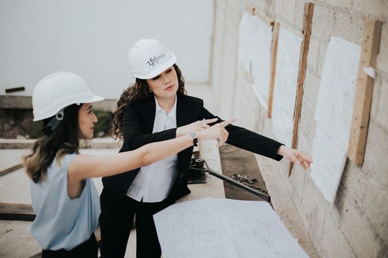 Women engineers reviewing blueprints